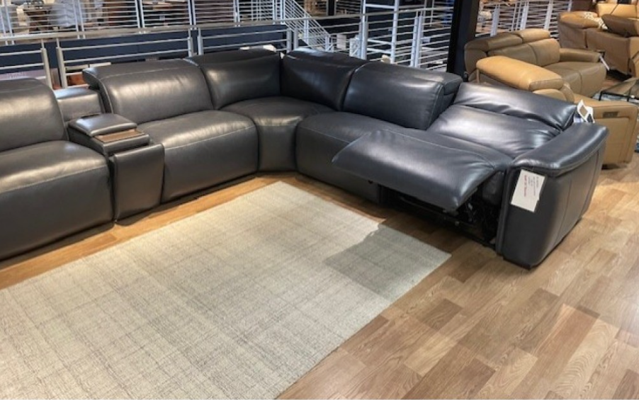 Dark gray leather sectional sofa with drink holder.