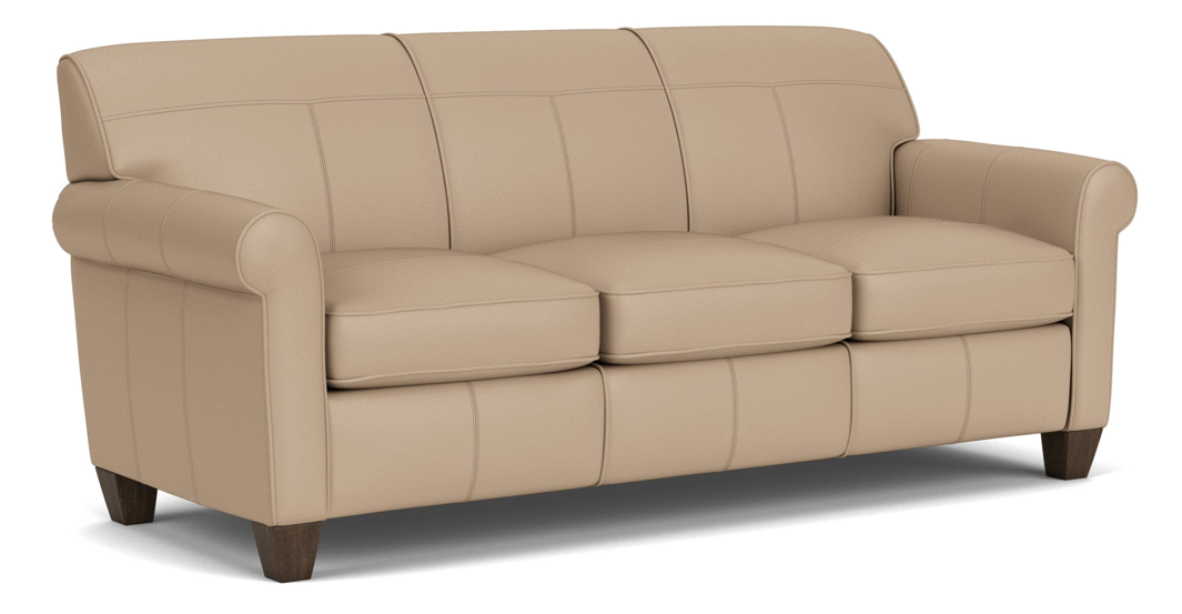 Beige leather sofa with three cushions and rolled arms, on dark wood feet.