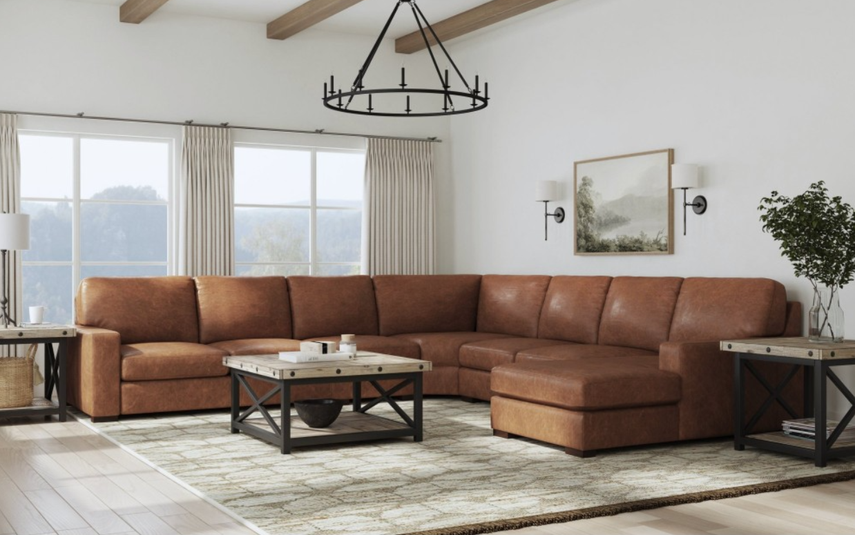 Brown leather sectional sofa in a rustic living room with a coffee table and rug.