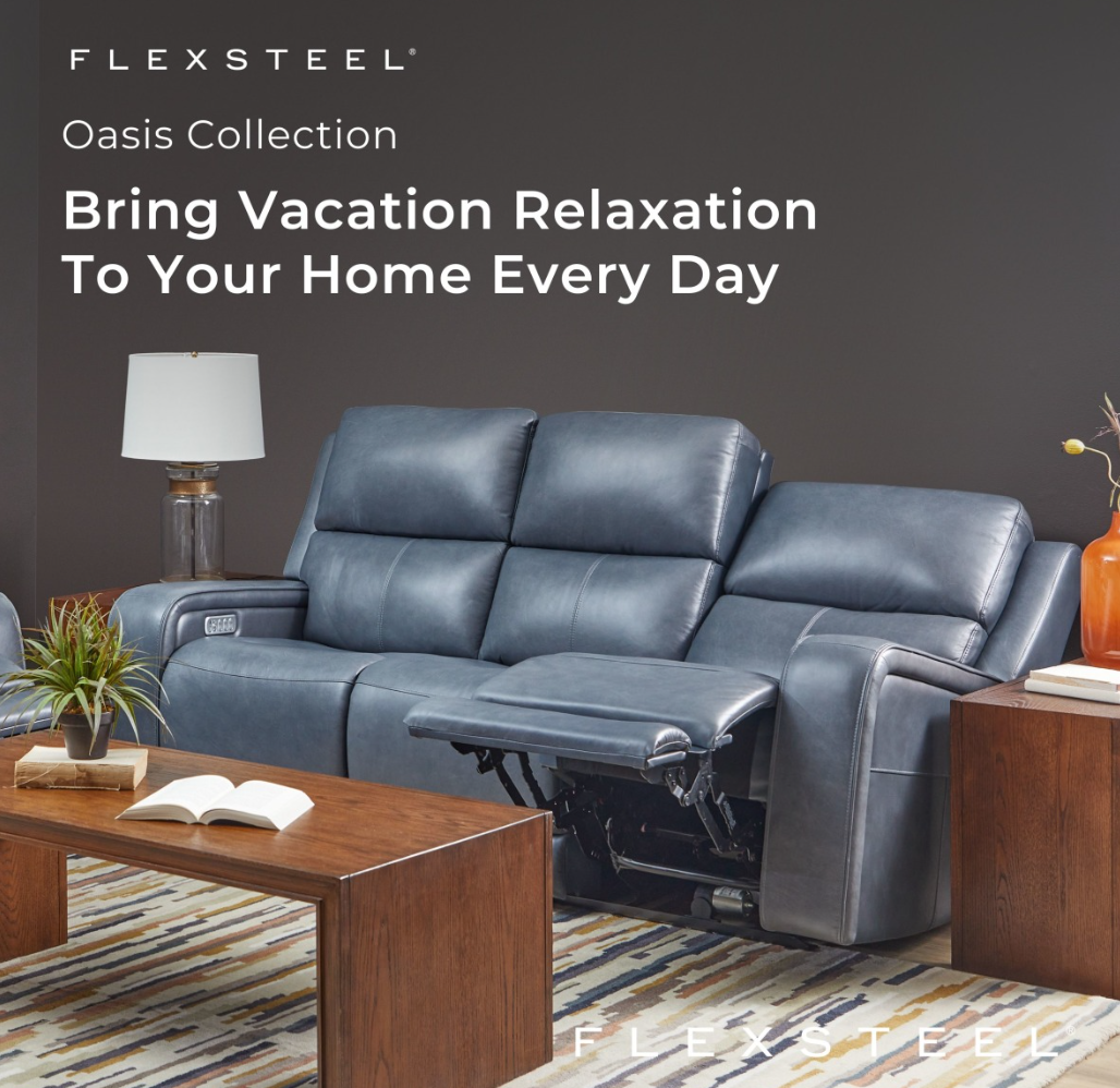 Blue leather reclining sofa in a living room; brown coffee table, lamp, and wood side table.