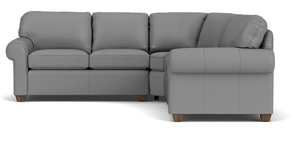 Cream-colored leather sectional sofa with a chaise lounge on a white background.