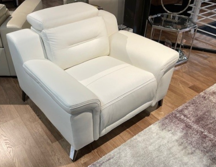 White leather armchair with headrest and armrests, sitting on a hardwood floor.