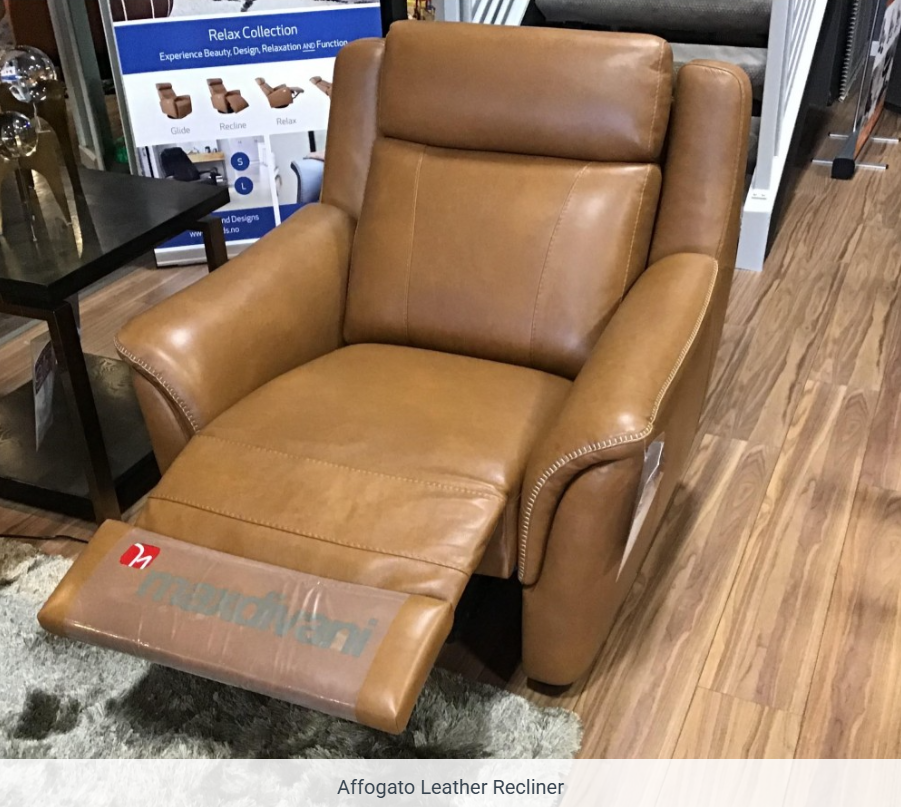 Brown leather recliner chair with footrest extended in a store setting.