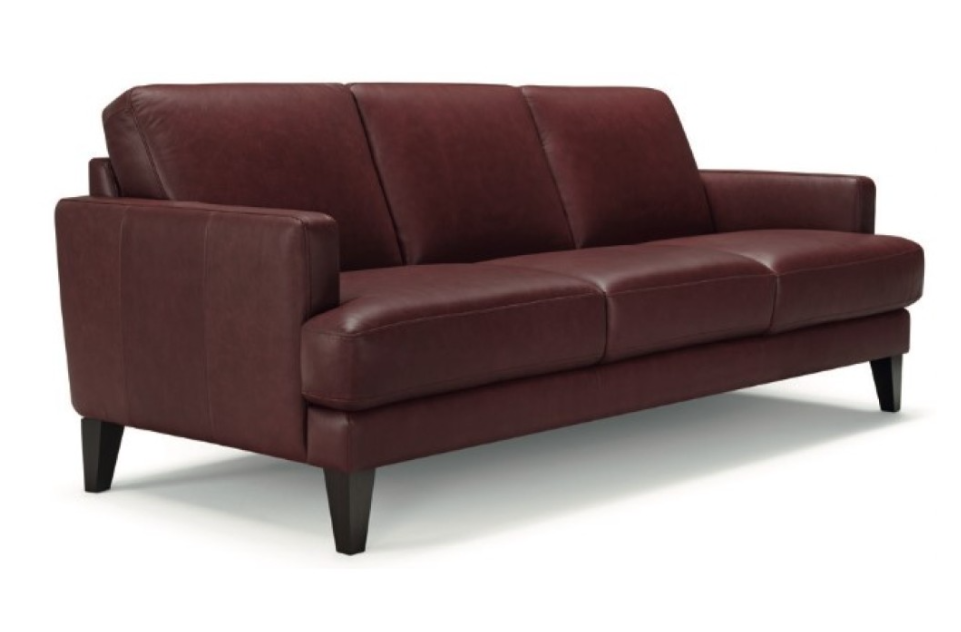 Burgundy leather sofa with three cushions and dark wooden legs.