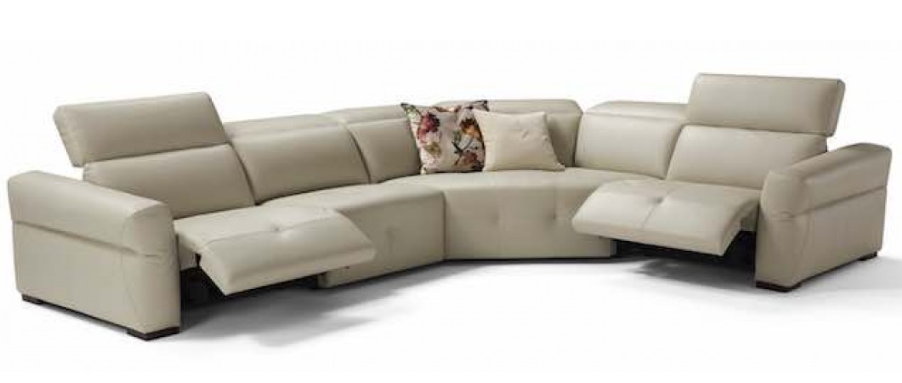 Beige leather sectional sofa with adjustable headrests and floral pillow.