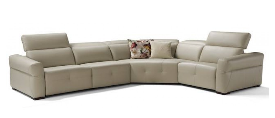 Beige leather sectional sofa with adjustable headrests and floral pillow.