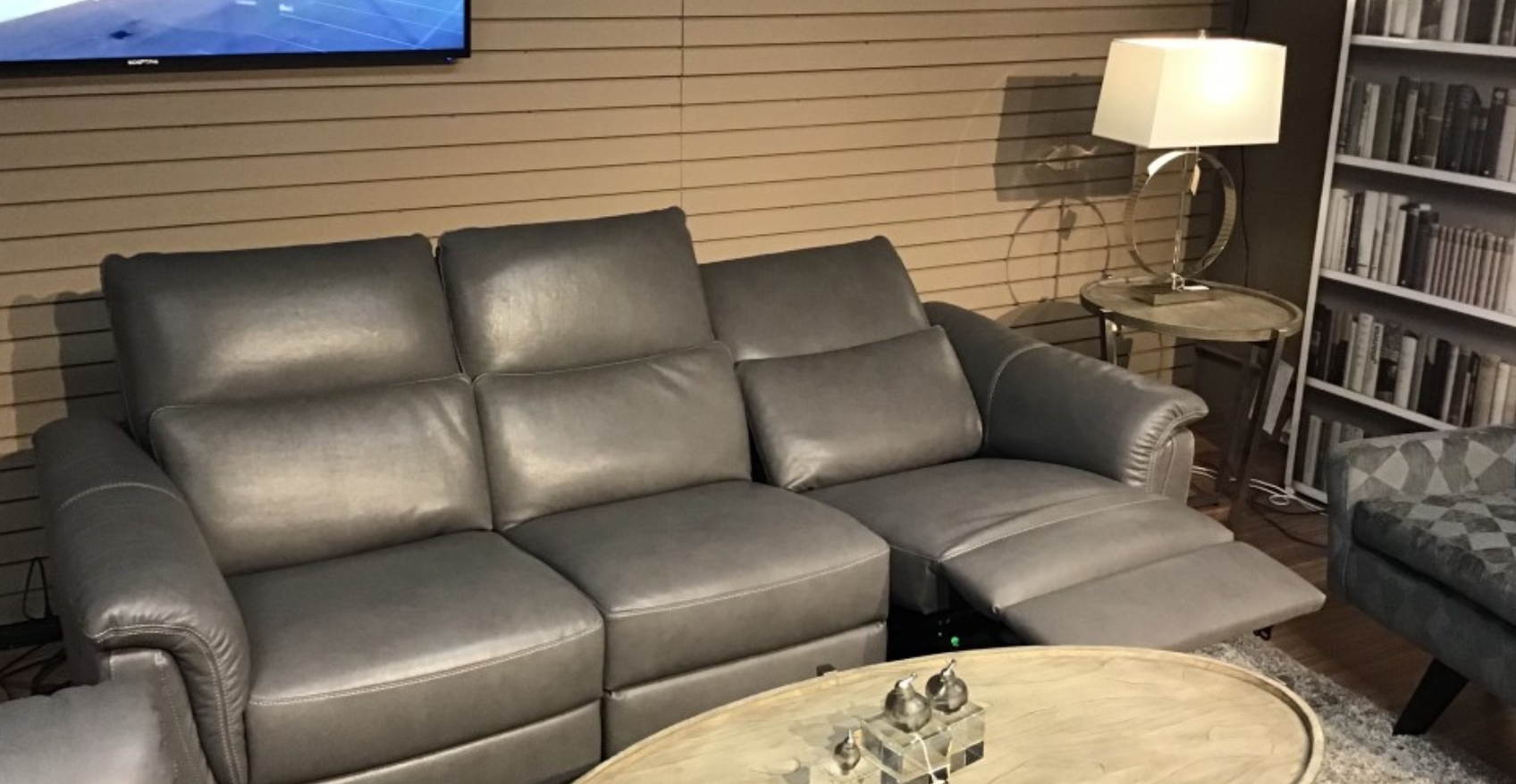 Blue leather two-seater sofa with two reclining seat sections.