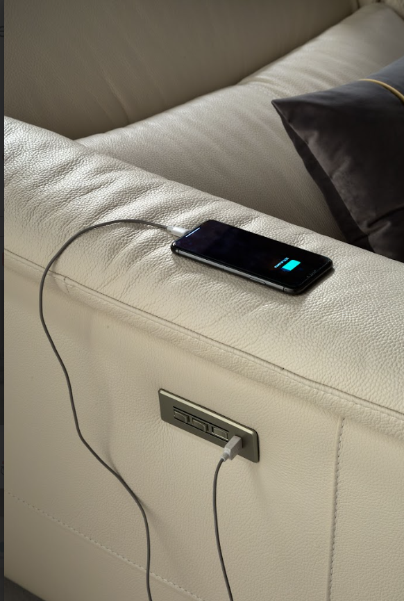 Cream-colored sectional sofa with recliner and cup holders in a living room setting.