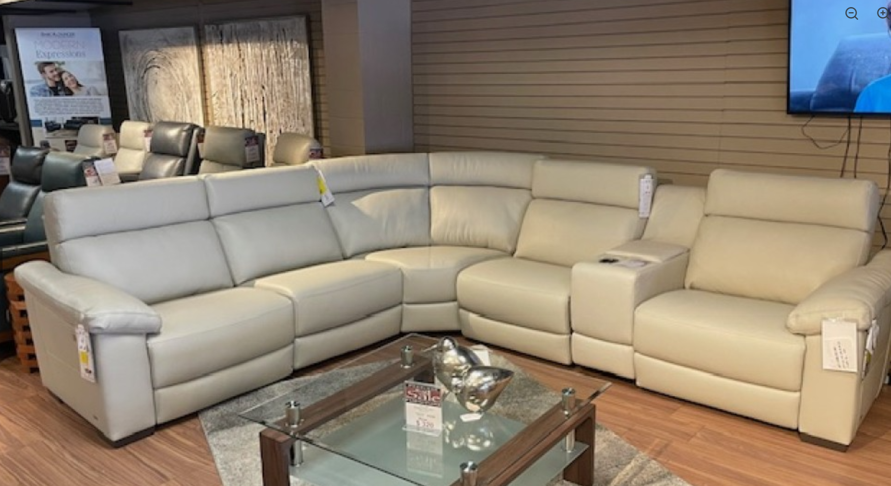 Beige sectional sofa with a reclining seat and chaise lounge.