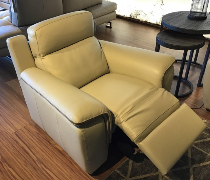 Beige leather recliner chair with footrest extended in a showroom.