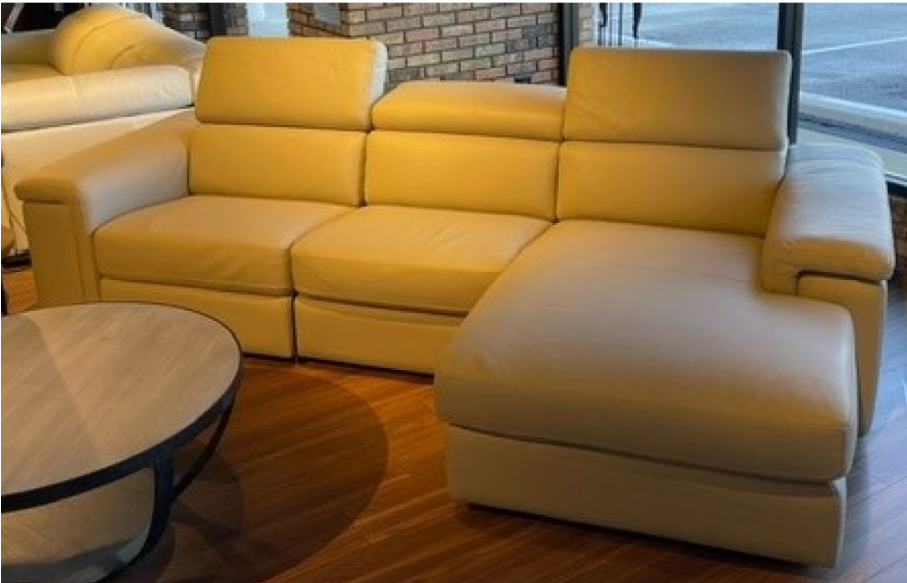 A large, light-colored sectional sofa with adjustable headrests and a reclining feature.