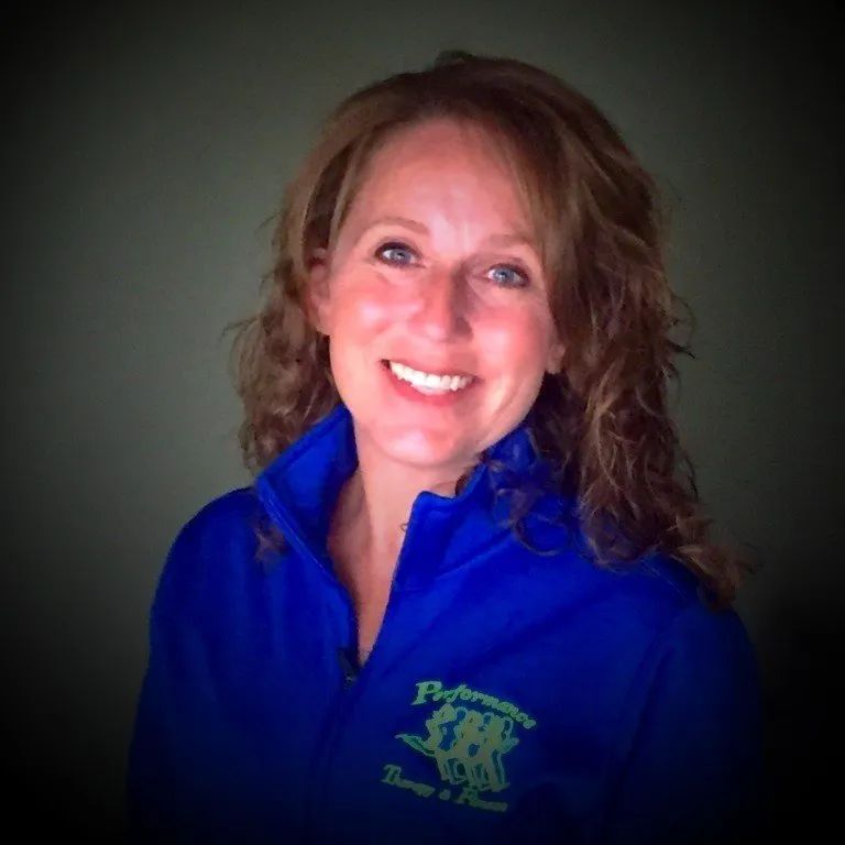 Woman smiling, wearing a blue jacket with 