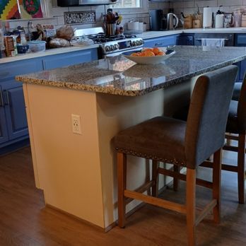 A kitchen with a large island with a bowl of fruit on it