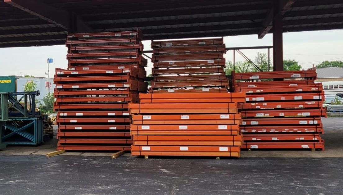 A bunch of pallets are stacked on top of each other in a parking lot