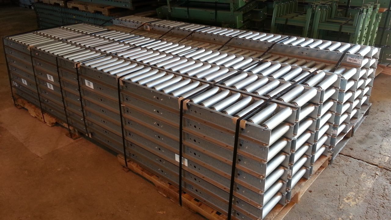 A pallet of conveyor belts stacked on top of each other on a wooden floor.