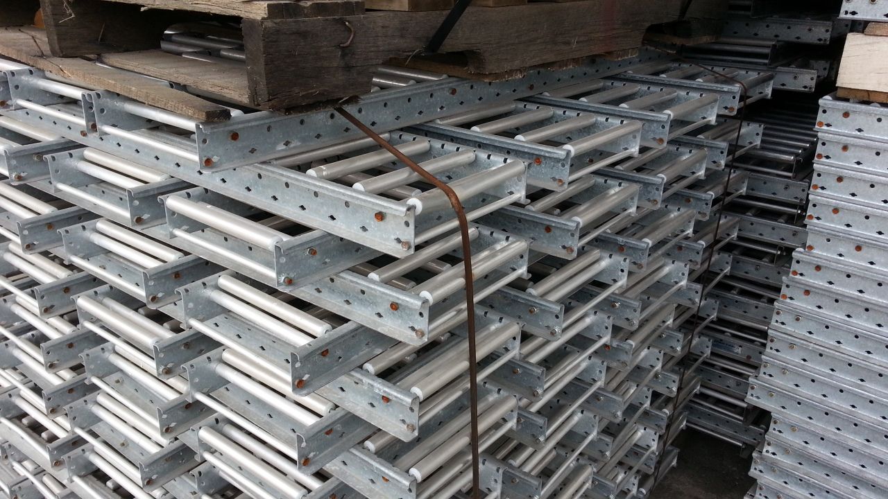 A stack of metal ladders sitting on top of a wooden pallet.