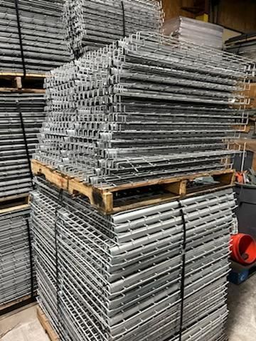 A stack of metal grates sitting on top of a wooden pallet.