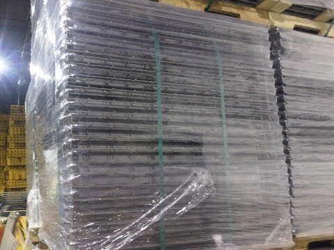 A stack of metal ladders sitting on top of a wooden pallet.