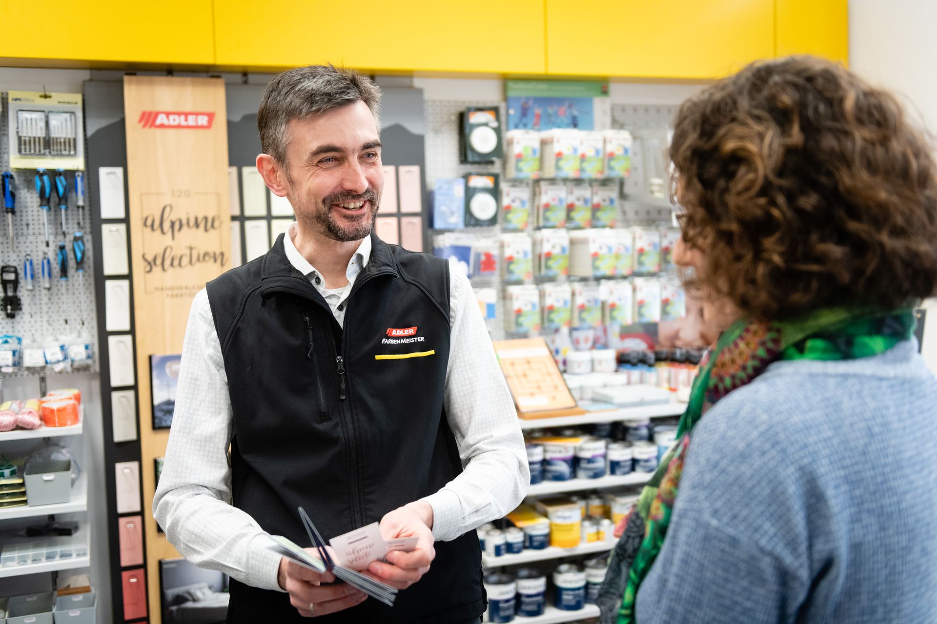 Ein Mann unterhält sich mit einem Kunden an einem Bedienschalter