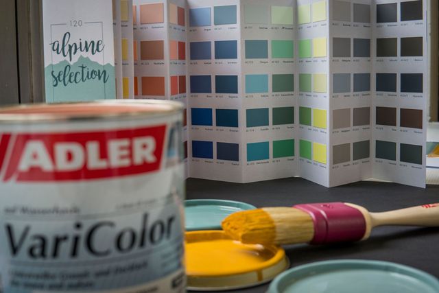 Farbdosen und Farbmuster in einem Farbenladen, im Vordergrund eine Adler VariColor-Dose.