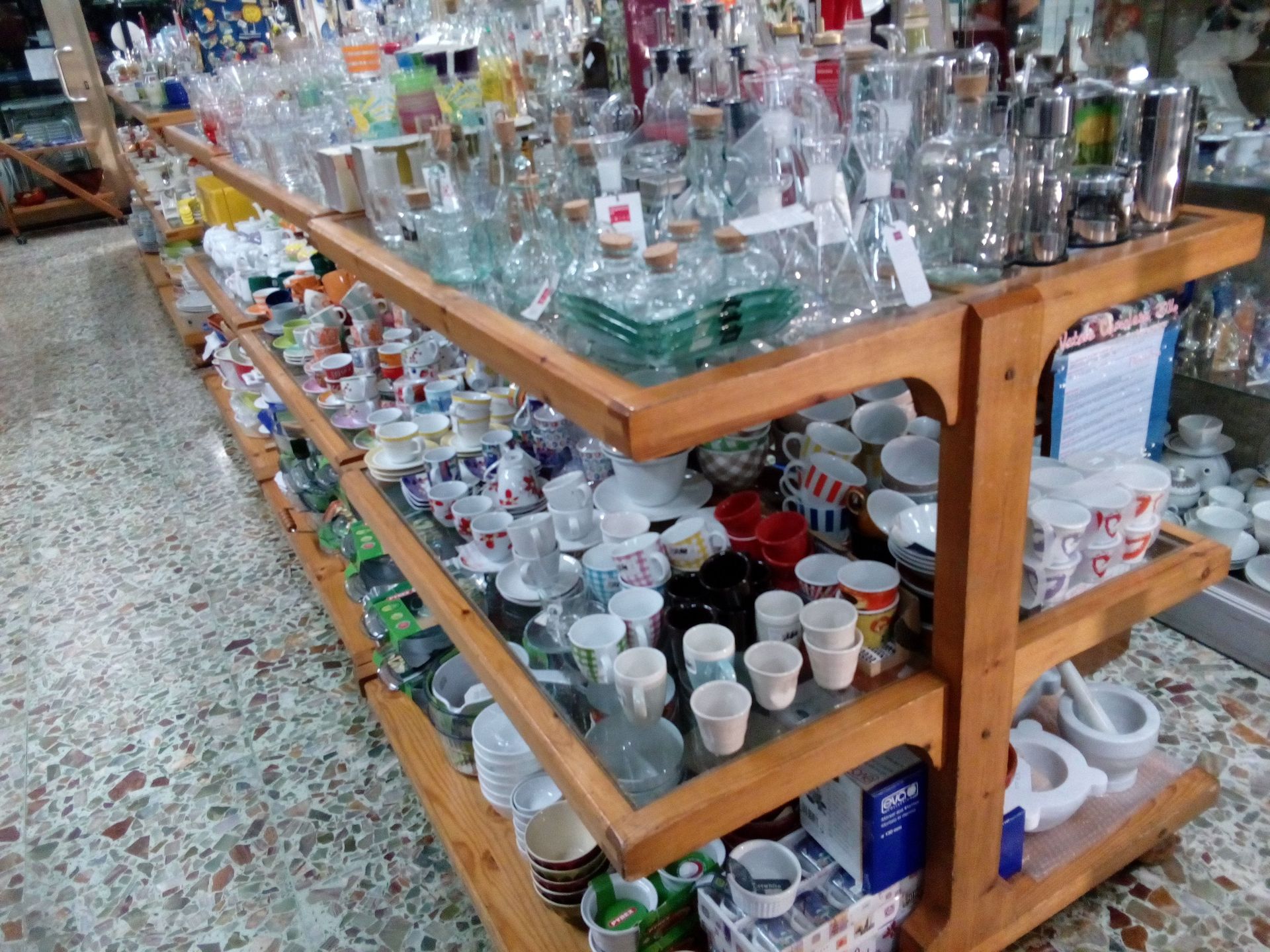 Uno scaffale di legno pieno di bicchieri e tazze
