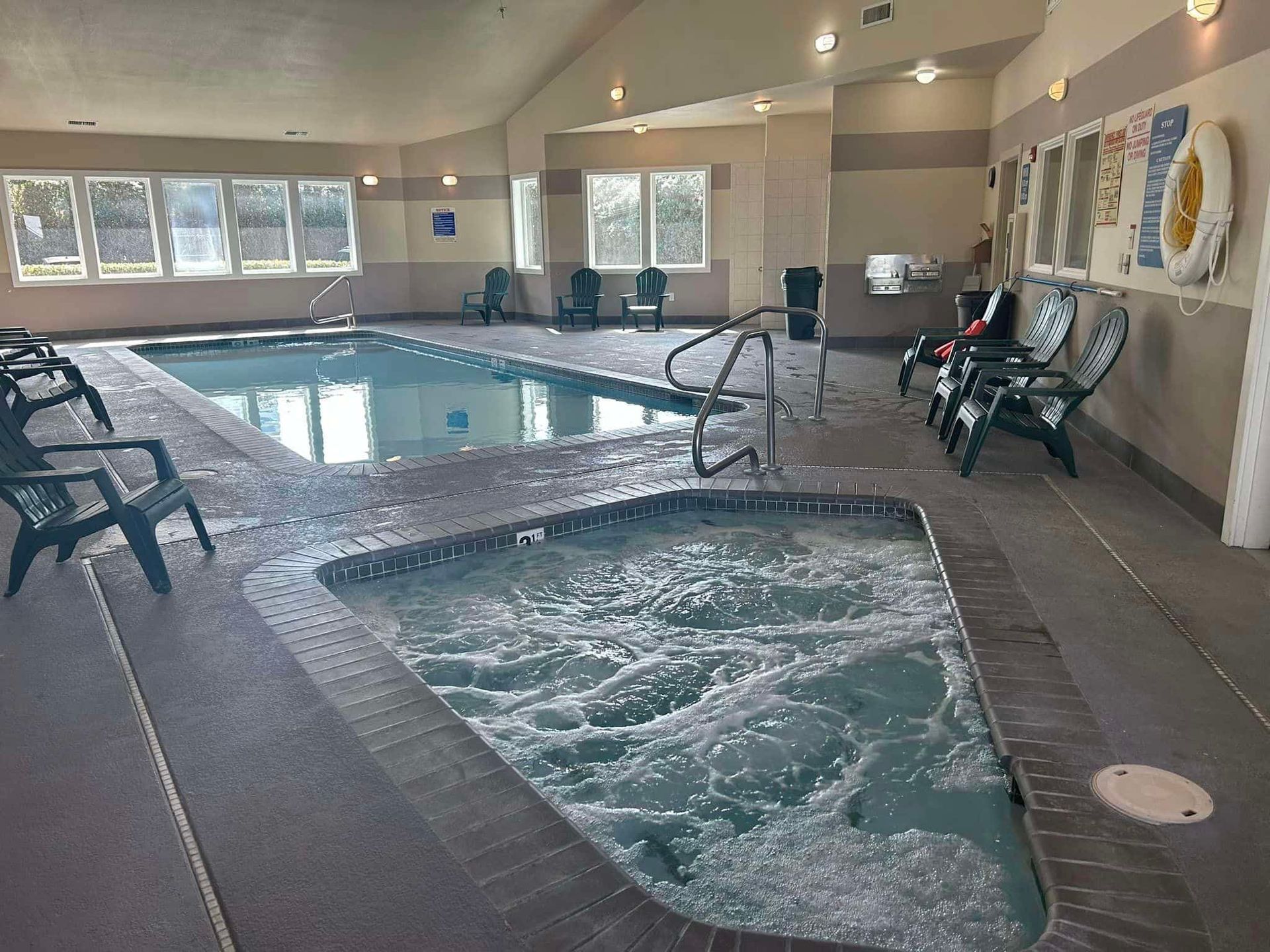 A large indoor swimming pool with a hot tub in the middle