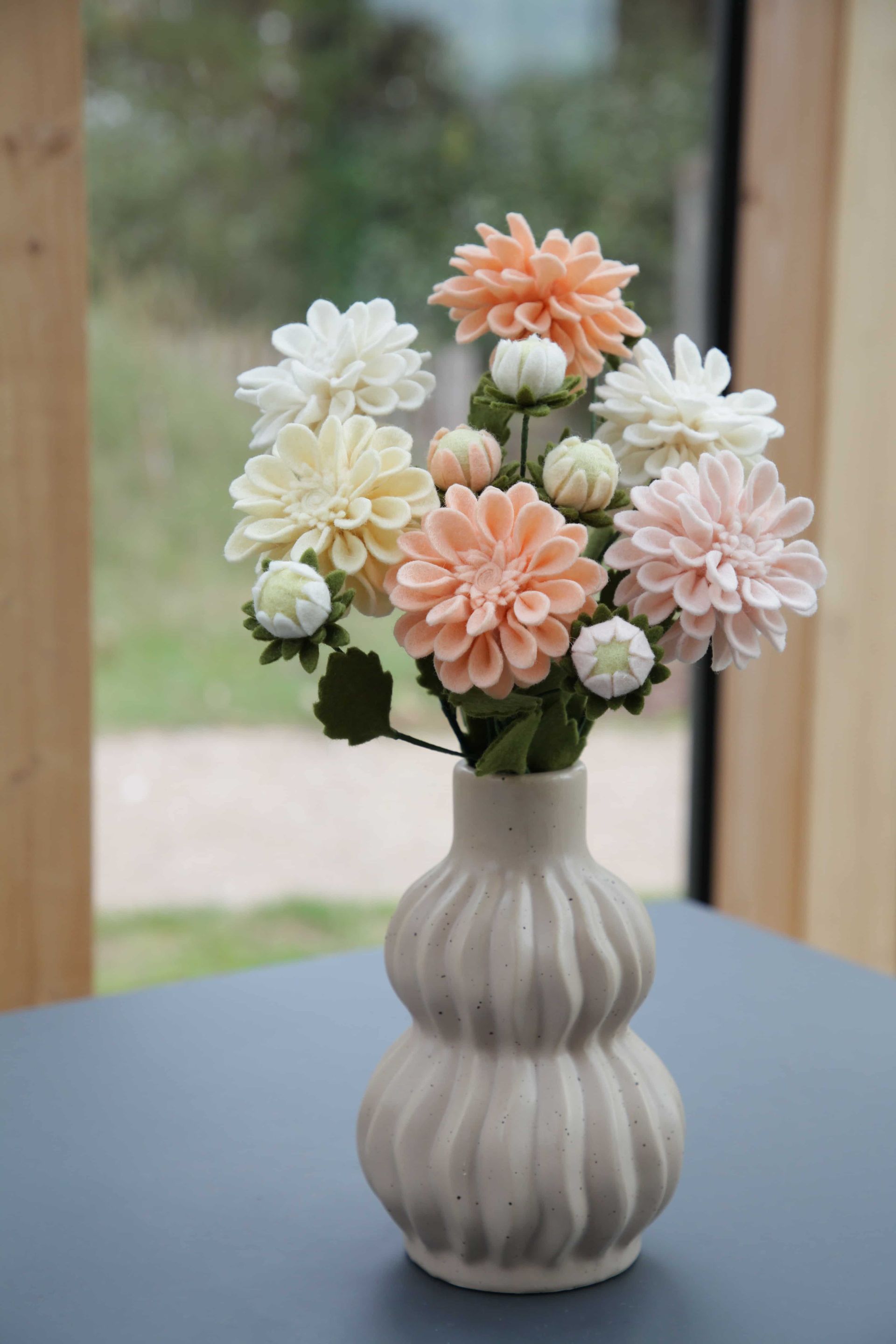 kleurrijk veldboeket in een rieten vaas, bloemen gemaakt van vilt