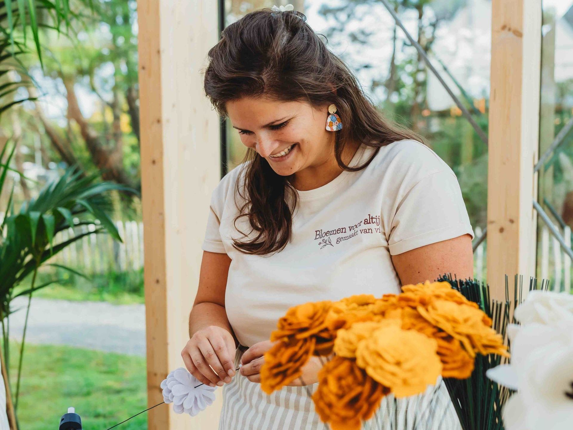 Nathalie lacht met viltbloemen op tafel