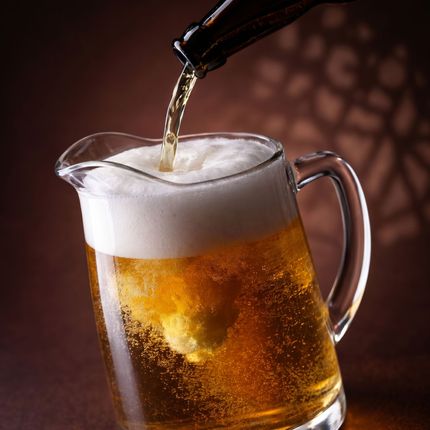 Beer pouring into a frosty mug with thick white foam