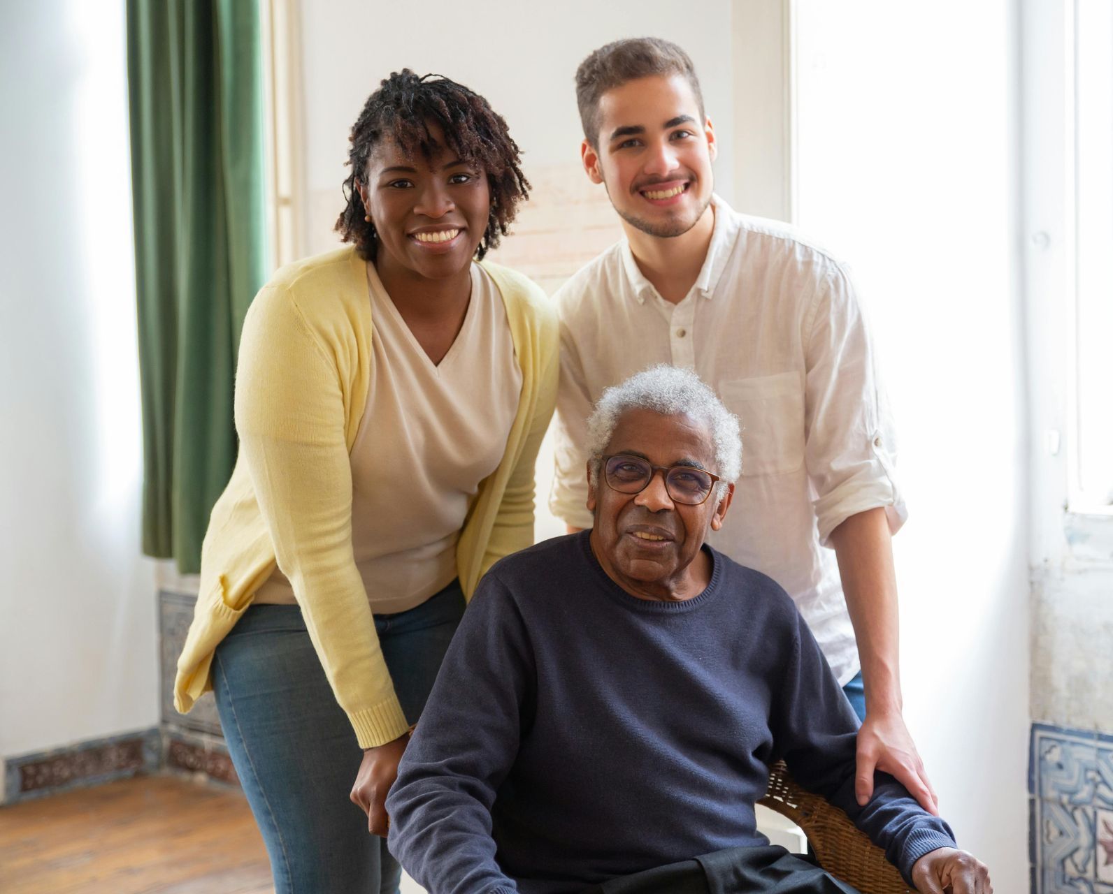 A group of people are posing for a picture with an elderly woman in a wheelchair.