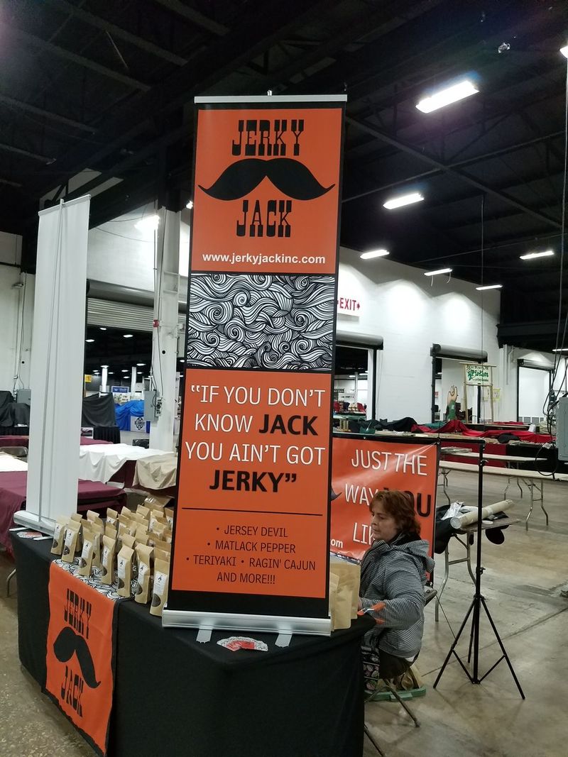 A man in a bigfoot costume is standing in front of a table that says jerky
