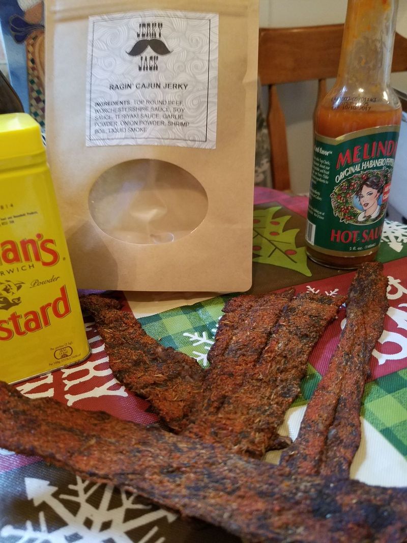 A man in a bigfoot costume is standing in front of a table that says jerky