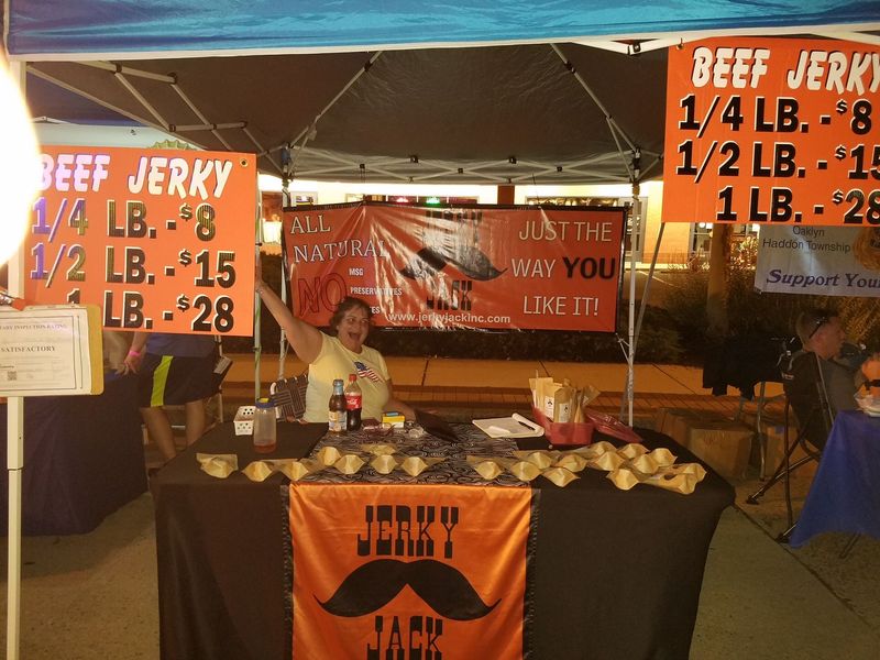 A woman stands behind a table selling beef jerky