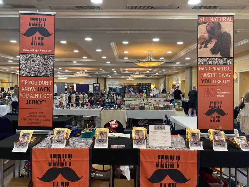 A large room filled with tables and signs advertising jerky