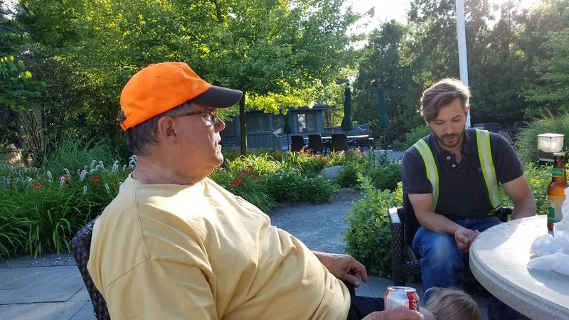 A man wearing an orange hat is sitting at a table with two other men.