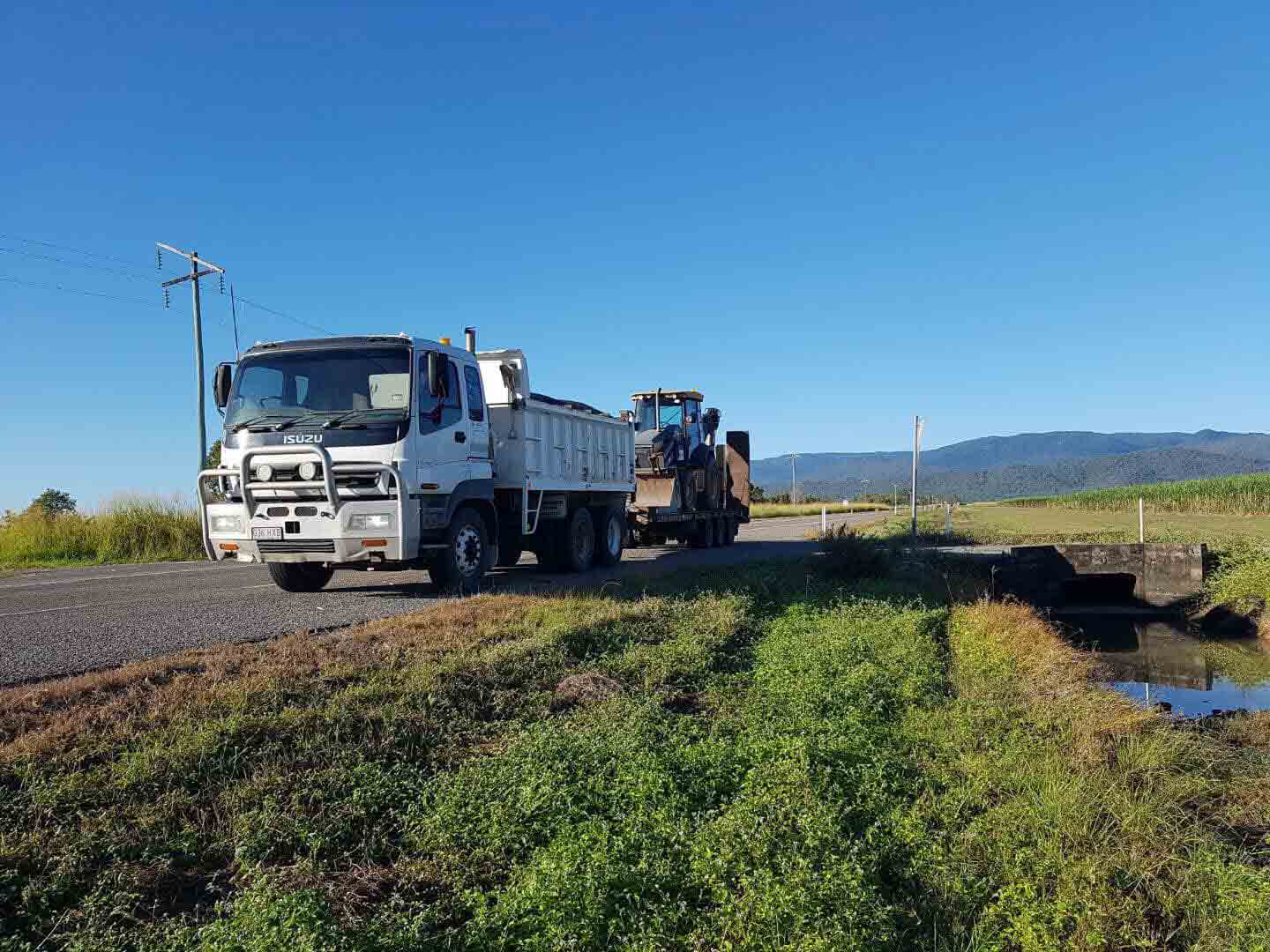 White Truck On Road — Excavator Hire in Townsville QLD