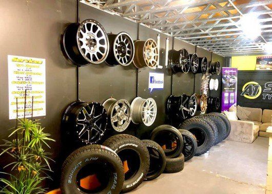 tyres and wheel rims mounted to wall in tyre shop