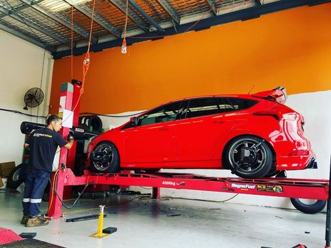 Red Car Getting Wheel Alignment Check