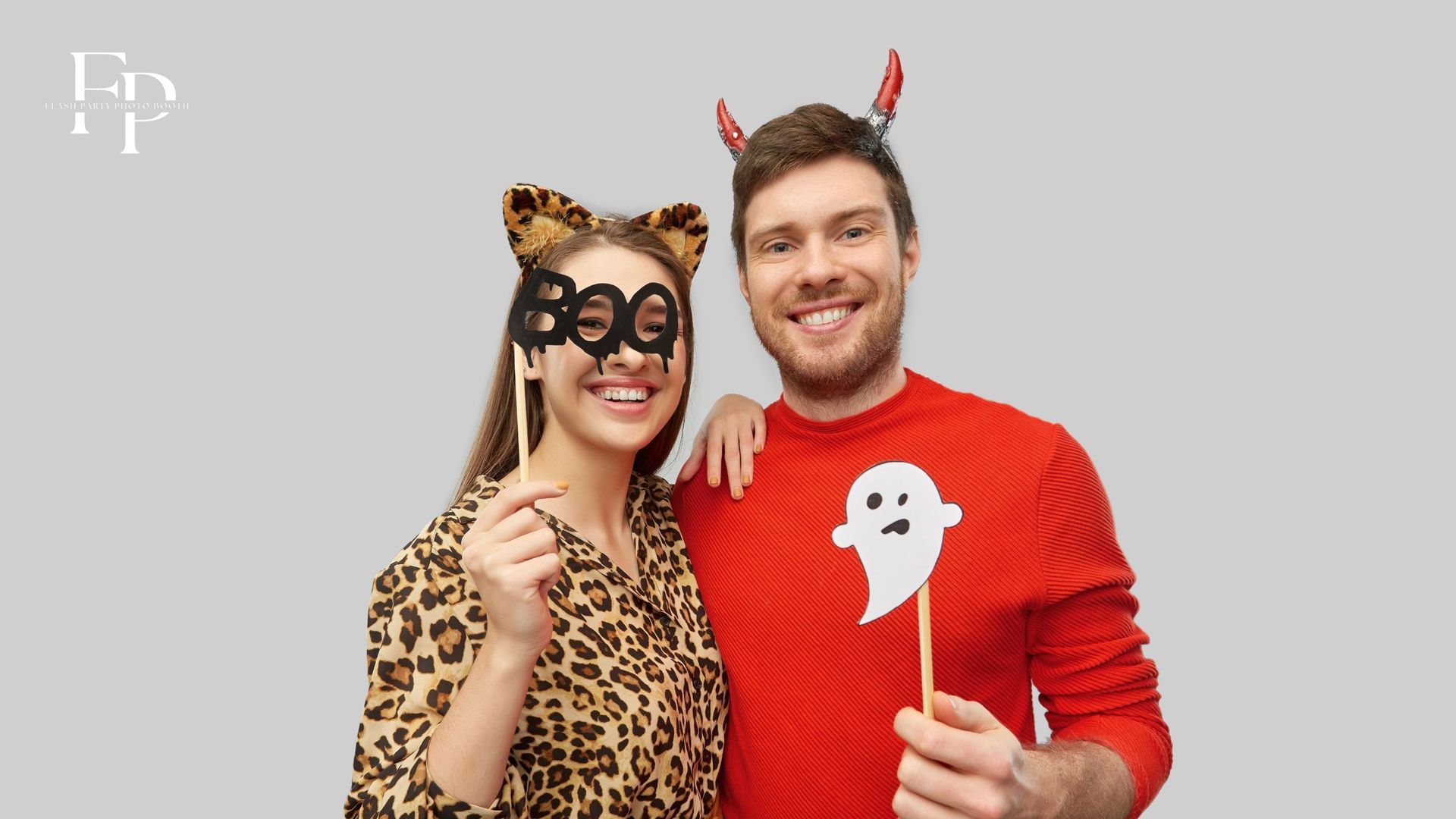 Two co-workers posing at a photo booth with scary props at a photo booth rental during a corporate event in DMV