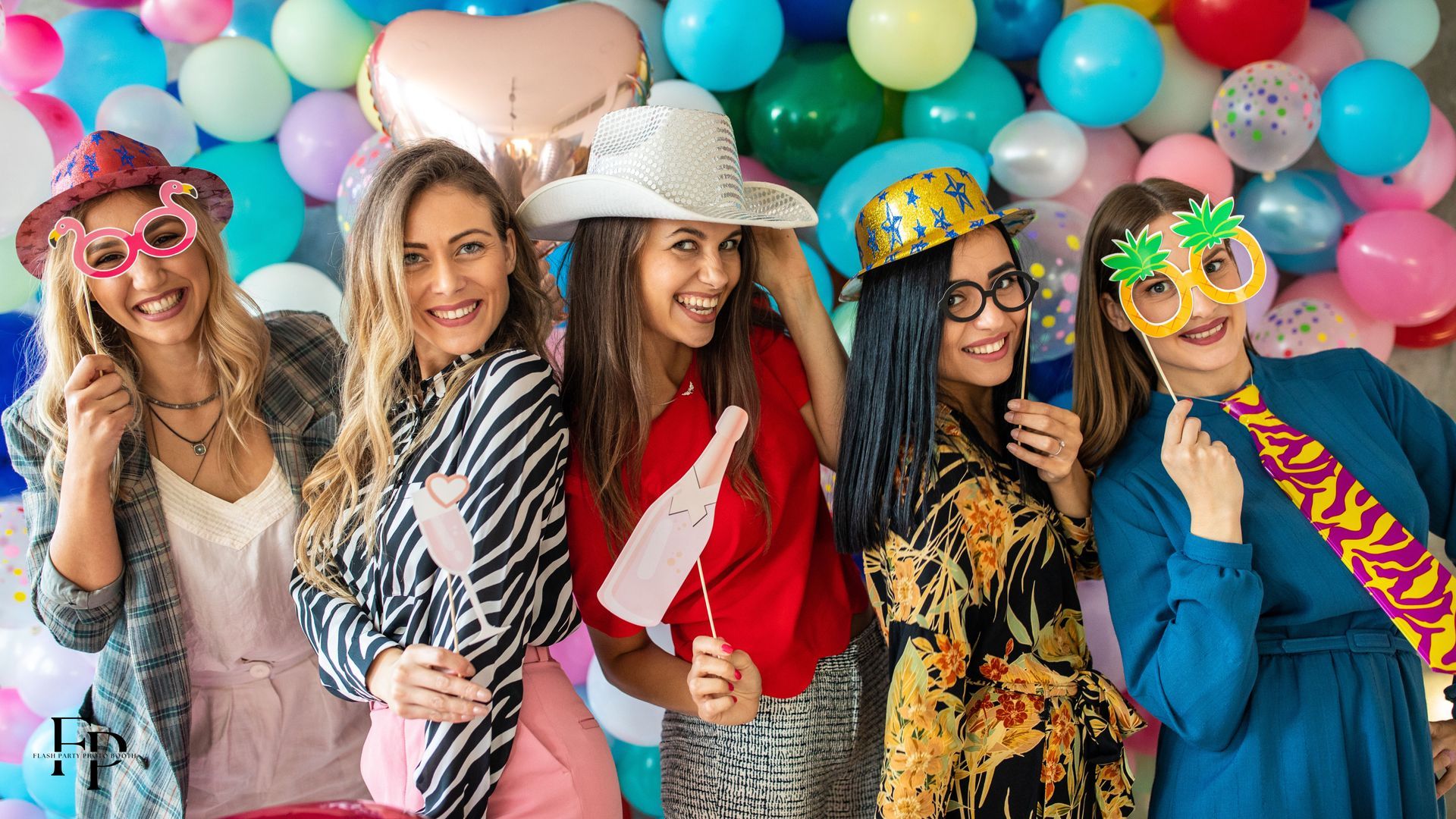 Five friends posing at a photo booth backdrop during a graduation party in North Austin