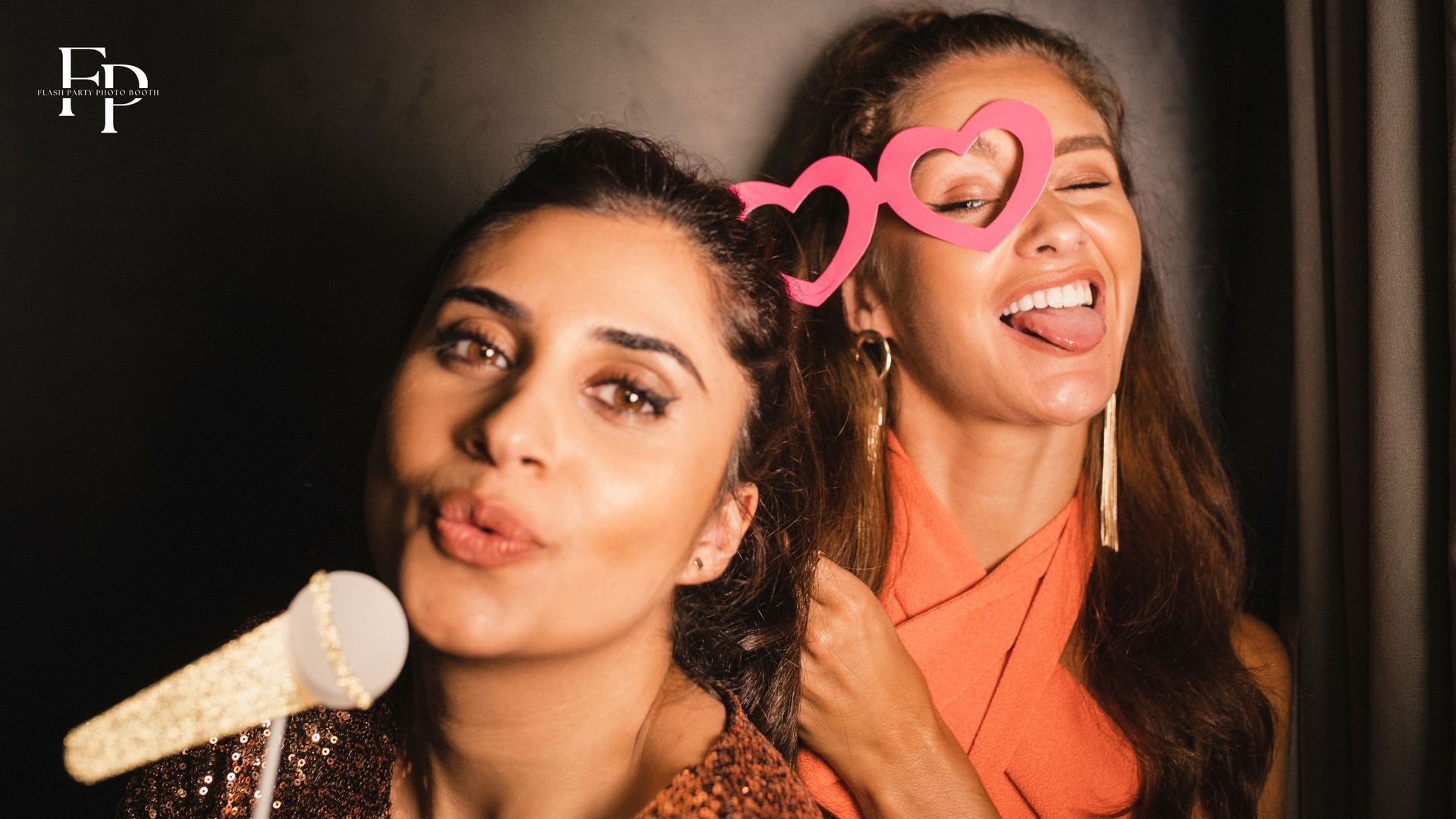 Two ladies smile for a photo in a Flash Party Photo Booth during a wedding reception in Atlanta
