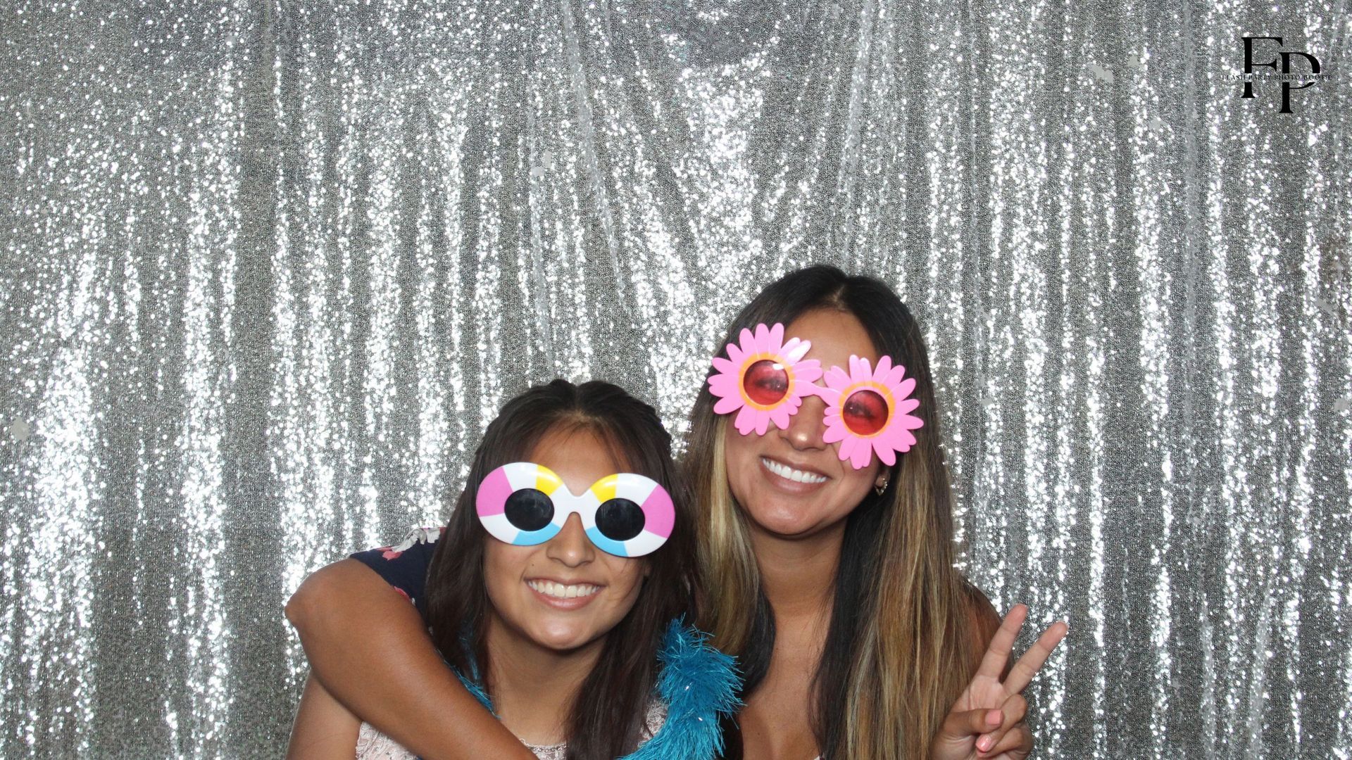 Two friends posing and enjoying at a photo booth rental in Houston