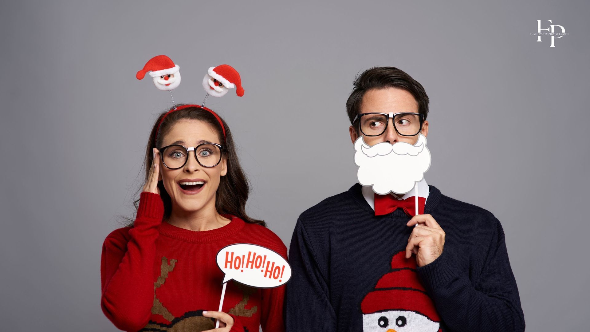 A woman and a guy pose with props at their year-end Christmas celebration.