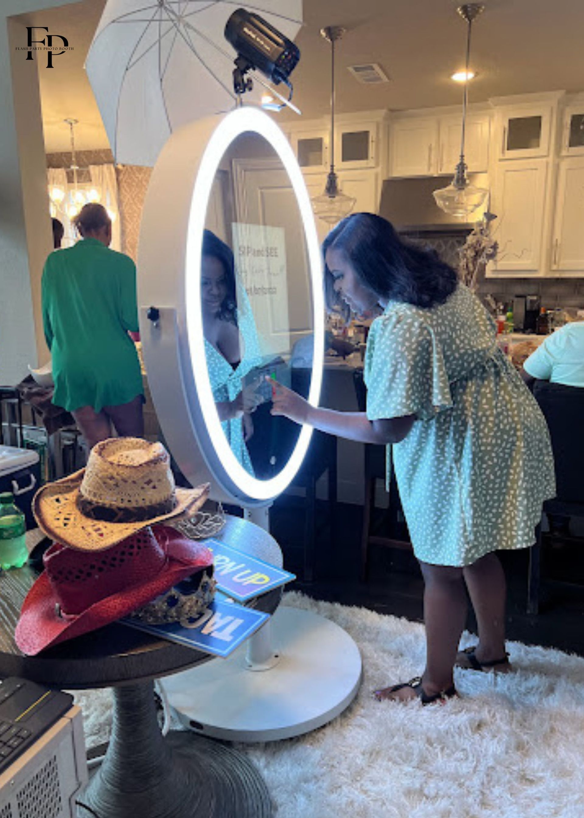 A woman stands before an Oval Mirror Photo Booth.
