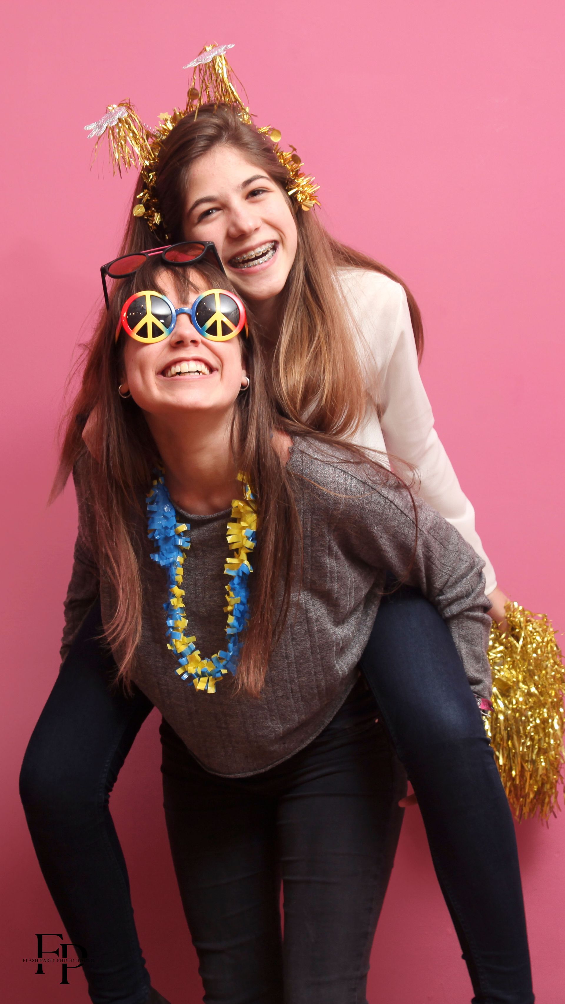 Two girls enjoy a fun-filled photo op with props at the graduation celebration.