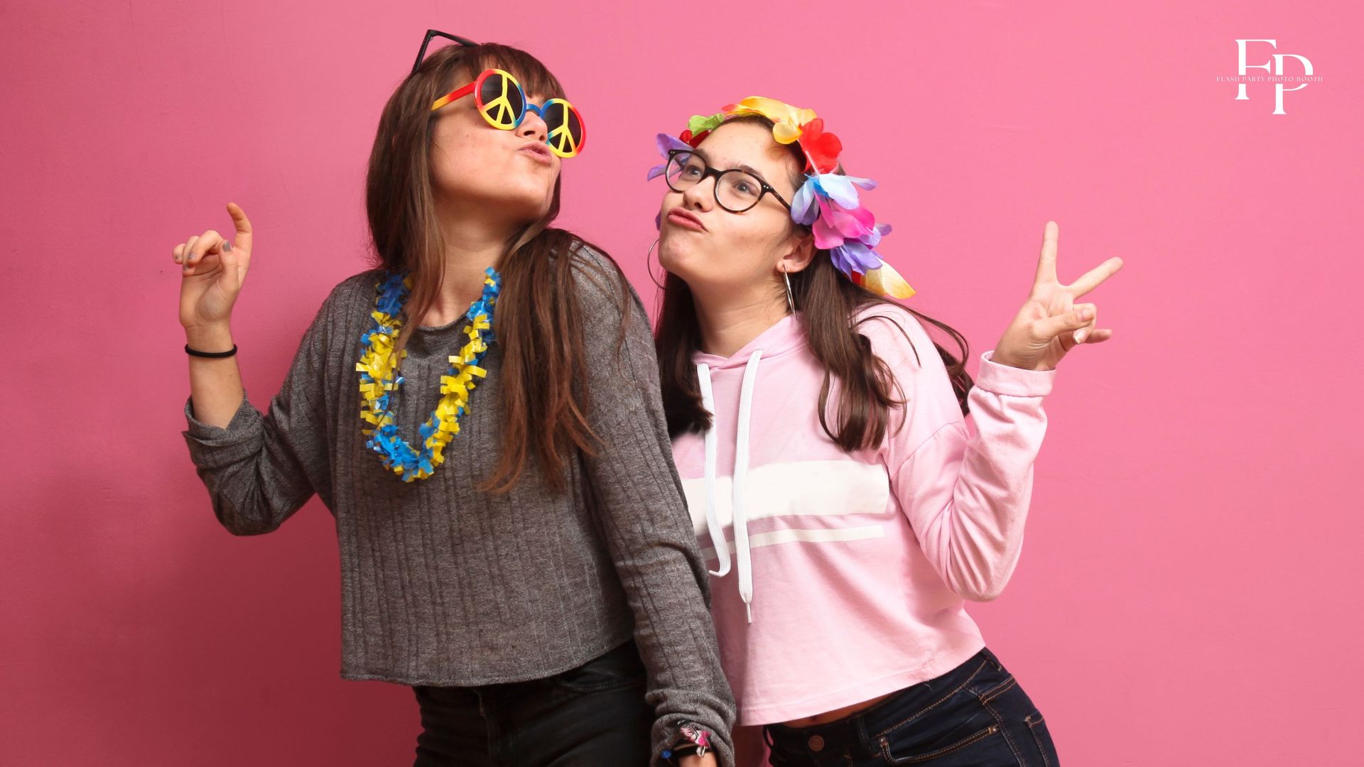 A candid shot of the birthday girl and her best friend at a photo booth setup for a birthday party in Midland