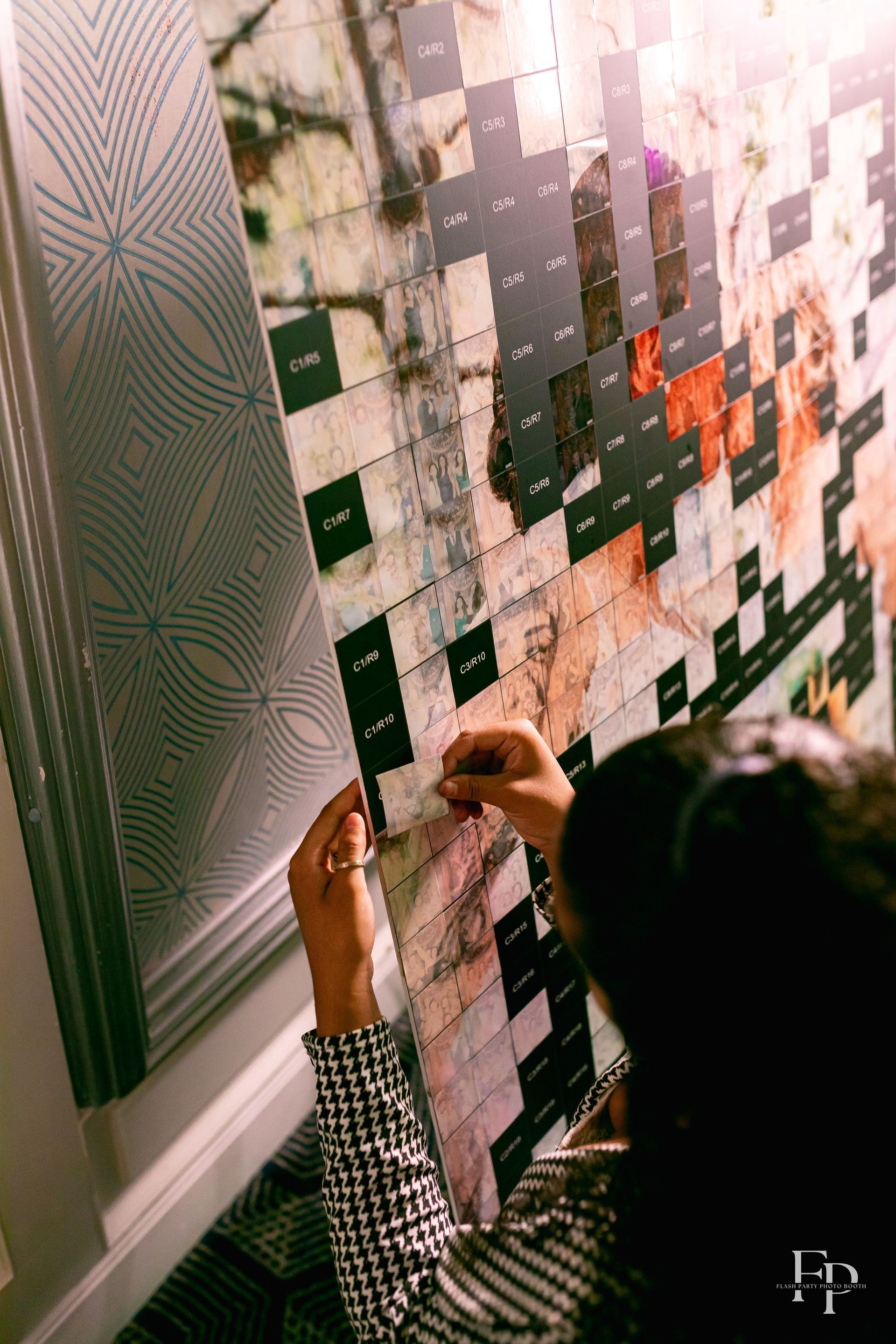 A person inserting a picture into the Mosaic Wall Photo Booth.