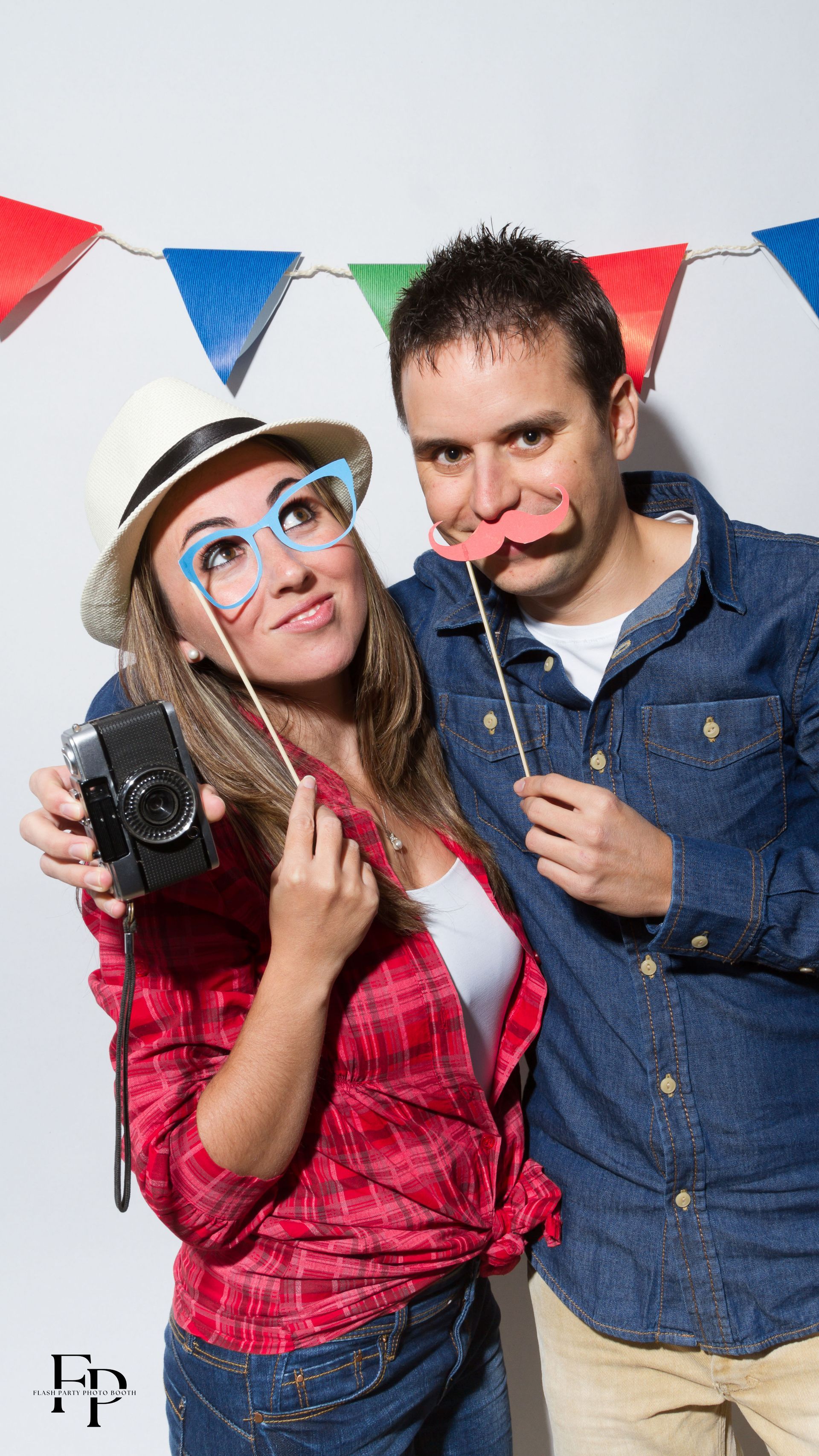 A man and woman strike a pose with props during a graduation party in Dallas