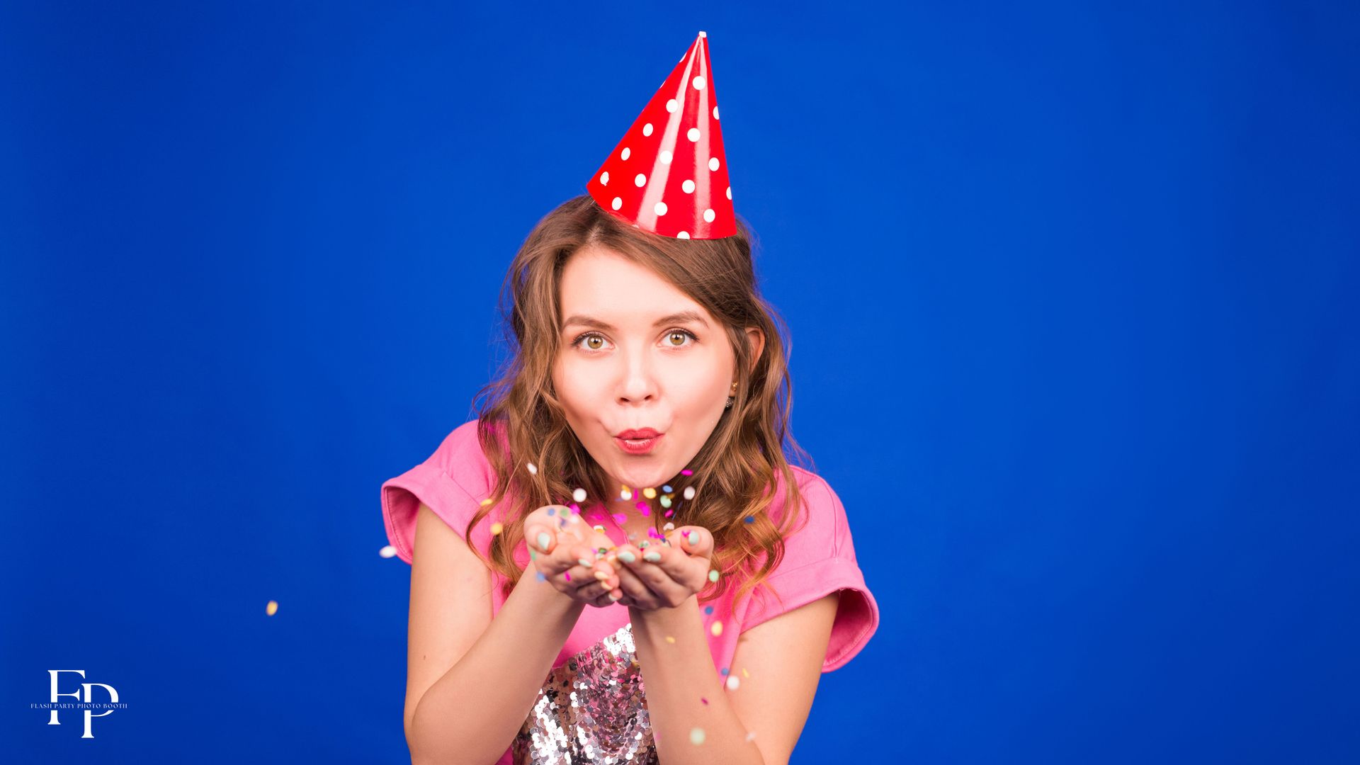 A girl blowing confetti at a special occasions photo booth rental in North Austin