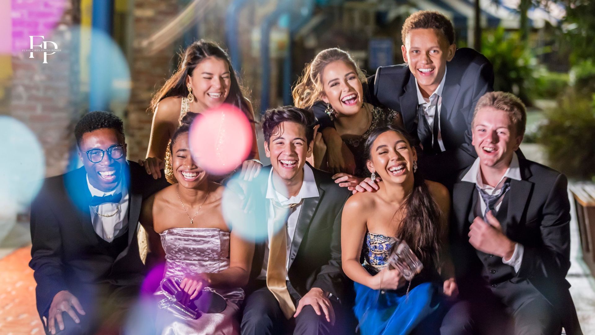 Friends strike poses in the lively flash party photo booth during San Antonio prom